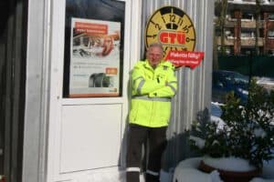 Der Kfz-Gutachter präsentiert sich vor seinem Firmengebäude für professionelle Fahrzeugbewertungen.