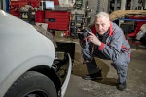 Der Kfz-Gutachter dokumentiert einen Unfallschaden mit Fotos für die Schadensbewertung und das Gutachten.