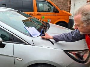 Kfz-Gutachter bei der Schadensbegutachtung eines Fahrzeugs