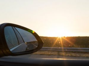 Außenspiegel eines Autos bei tief stehender Sonne als Symbol für Blendung und Unfallgefahr