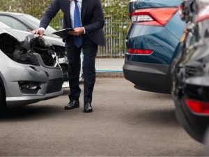 Kfz Sachverständiger begutachtet einen Frontschaden nach einem Unfall und dokumentiert den Schaden