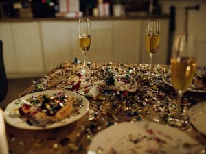 Autounfall an Silvester. Tisch nach einer Feier mit Konfetti Essensresten und Gläsern als Motiv für Schaden und Reinigungsaufwand.