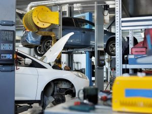 Autowerkstatt mit Fahrzeugen auf Hebebühne und Reparaturarbeiten als Motiv für Unfallgutachten und Reparaturkosten. Kfz Werkstatt von Ralf Wandhoefer in Gelsenkirchen.