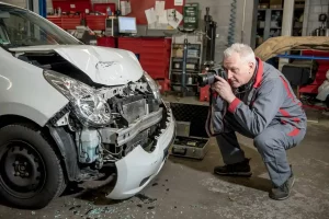 Ralf Wandhöfer dokumentiert ein beschädigtes Unfallfahrzeug für ein KFZ Gutachten in der Werkstatt